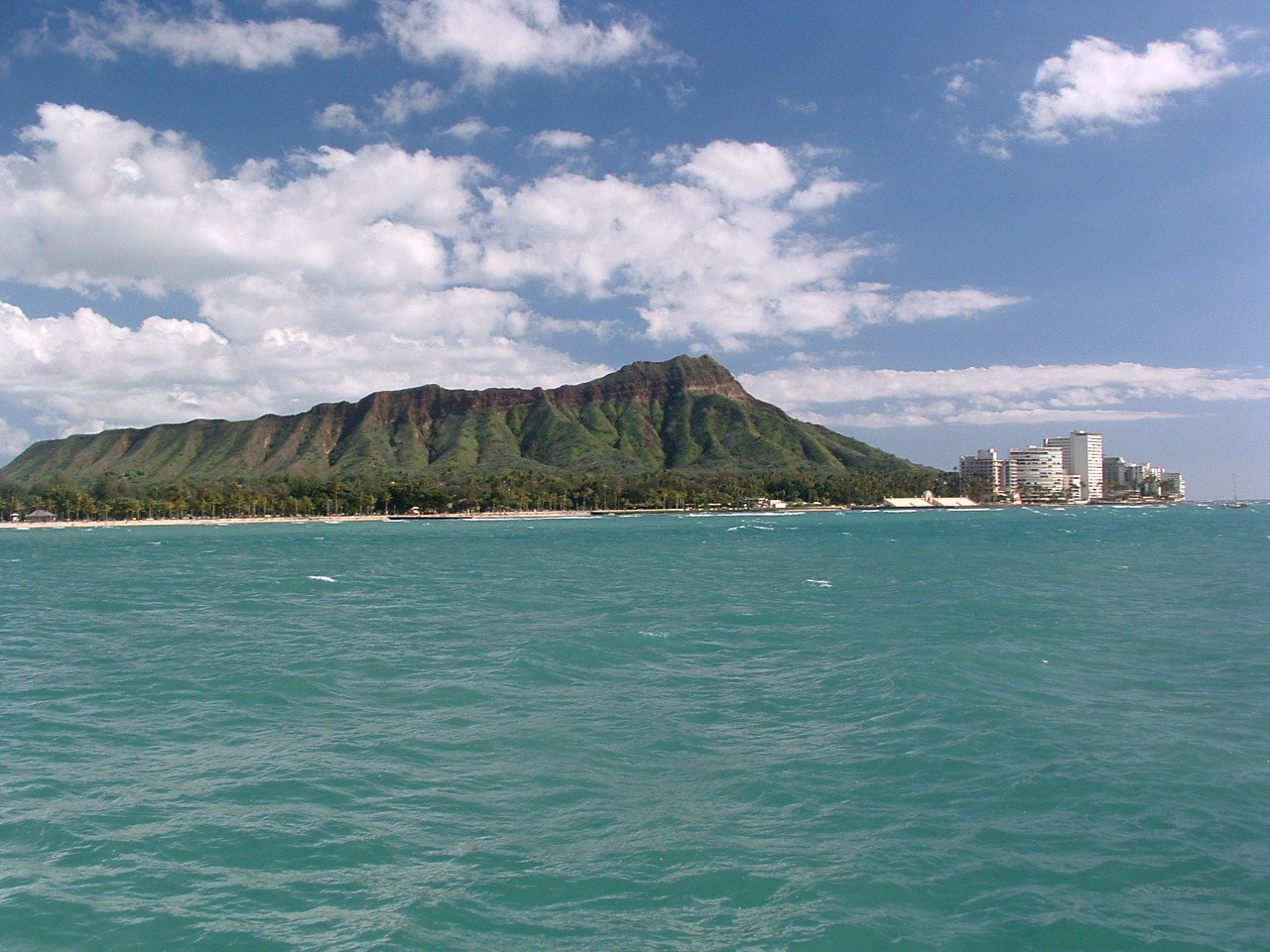 Diamond Head's green volcanic ridge along the turquoise ocean near Waikiki